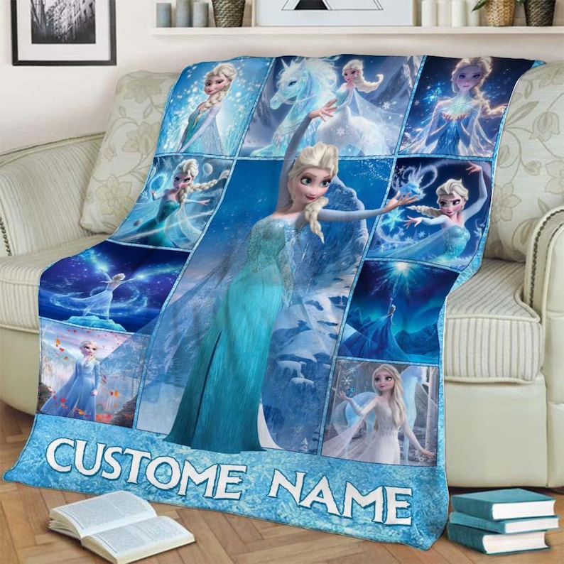May include: A blue fleece blanket featuring multiple images of a princess in a blue dress. The blanket has the text "CUSTOM NAME" in white letters on a light blue background. The blanket is draped over a beige sofa.