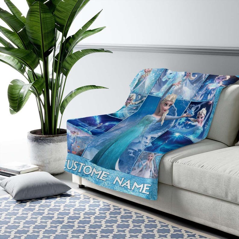 May include: A blue fleece blanket featuring a collage of images of a character from a popular animated film. The blanket has a light blue border with the text "CUSTOM NAME" in white. The blanket is draped over a white sofa.