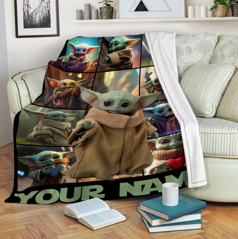 May include: A plush blanket featuring a collage of images of a green alien character with large ears and brown robes. The blanket has the text "YOUR NAME" in large, bold letters at the bottom.