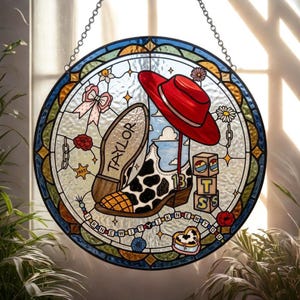 May include: A circular stained glass suncatcher featuring a cow-print cowboy boot with the number 13, a red hat, a pink bow, and blocks spelling TSS. The text TAYLOR is on the boot sole, and the phrase I KNEW IT I KNEW YOU is on a beaded string.