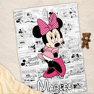 May include: A pink Minnie Mouse blanket featuring a comic strip design with black and white panels and the text "Walt Disney's Mickey Mouse." Minnie Mouse is in the center, wearing a pink dress and bow. The name "Marlee" is at the bottom.