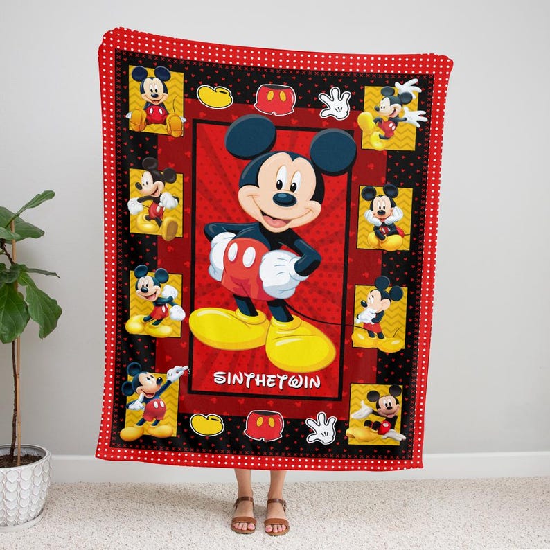 May include: A red and black Mickey Mouse blanket featuring multiple images of Mickey Mouse. The blanket has a red border with white polka dots. The center of the blanket has a large image of Mickey Mouse with the text "SINTHETWIN".