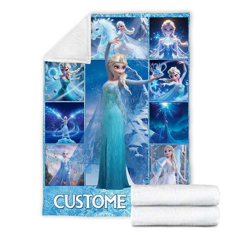 May include: A blue and white blanket featuring multiple images of a blonde princess in a blue dress. The word "CUSTOM" is at the bottom of the blanket. Two white folded towels are at the bottom right.
