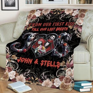 May include: A black throw blanket featuring a central heart graphic with two skeletal characters, surrounded by floral patterns in shades of cream, brown, and pink. The text reads FROM OUR FIRST KISS TILL OUR LAST BREATH and JOHN & STELLA.