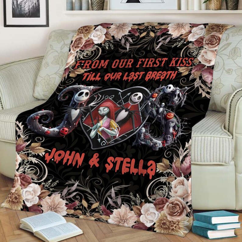May include: A black throw blanket featuring a central heart graphic with two skeletal characters, surrounded by floral patterns in shades of cream, brown, and pink. The text reads FROM OUR FIRST KISS TILL OUR LAST BREATH and JOHN & STELLA.