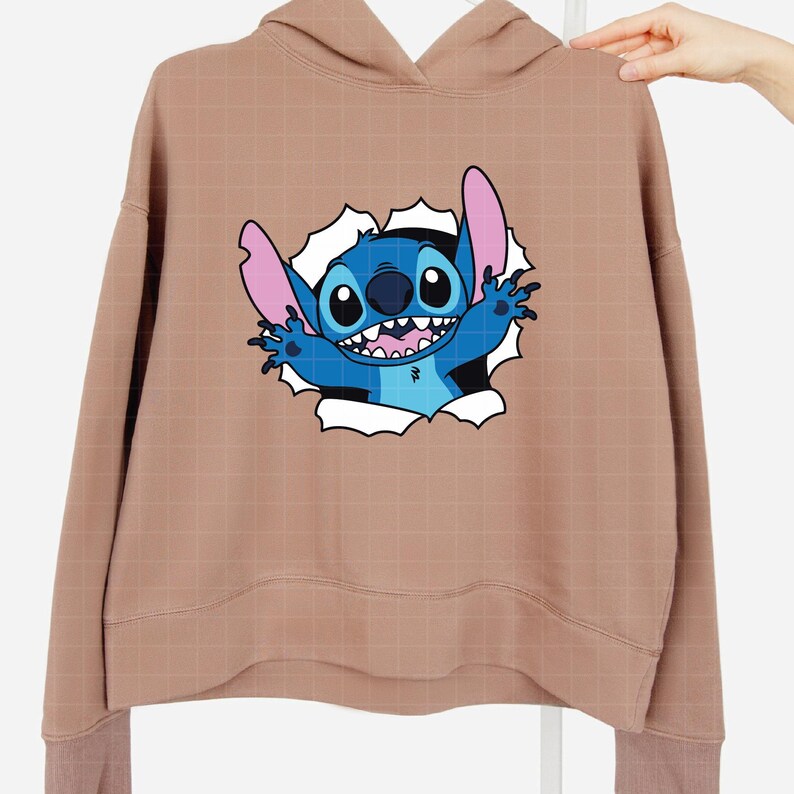 Pu&ograve; includere: Una felpa con cappuccio color beige con una grafica del personaggio Stitch che sfonda un sfondo bianco strappato. Stitch &egrave; blu con grandi orecchie, un ampio sorriso e le braccia tese. La felpa ha un cappuccio con coulisse e polsini a coste.