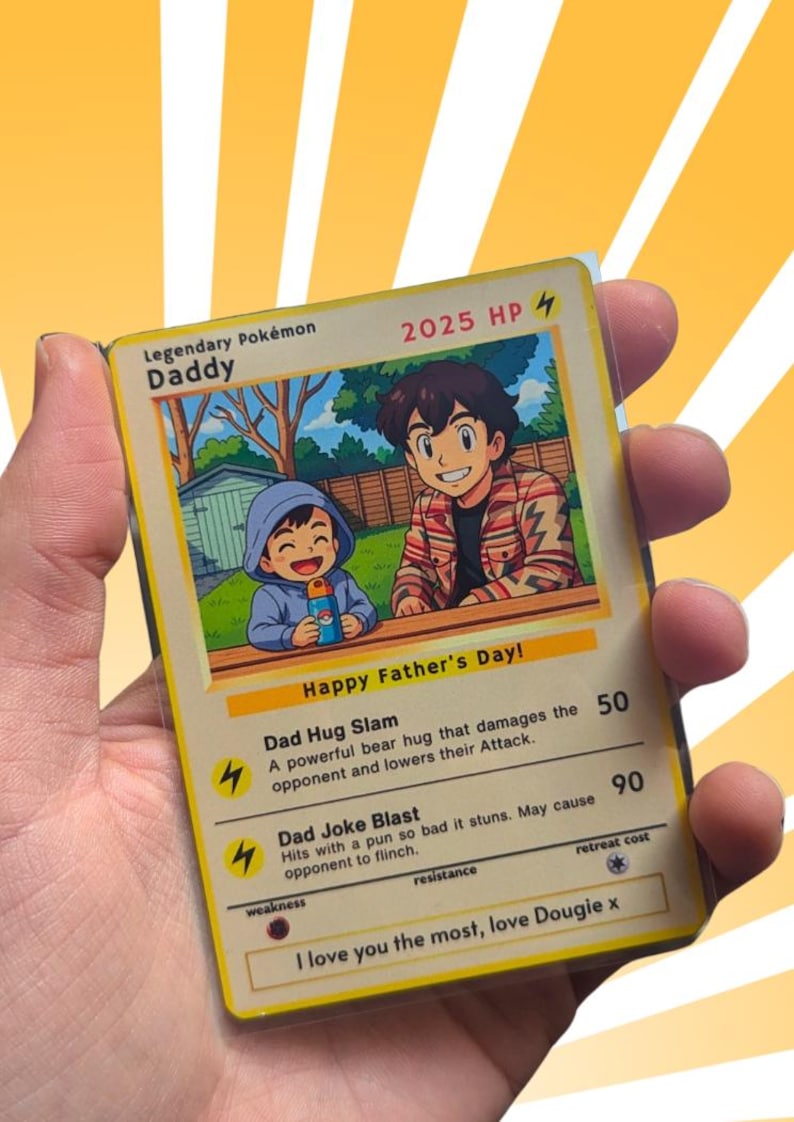 Pode incluir: Um cart&atilde;o Pok&eacute;mon Lend&aacute;rio com uma ilustra&ccedil;&atilde;o de desenho animado de um pai e filho, com o texto "Happy Father's Day!". O cart&atilde;o diz "Daddy" e inclui descri&ccedil;&otilde;es de ataque. O cart&atilde;o &eacute; mantido em uma manga protetora.