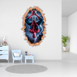 May include: A wall decal featuring Spider-Man in a red and blue suit, hanging upside down. The decal is designed to look like a hole in the wall, revealing a cityscape with lightning.
