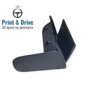 Könnte beinhalten: Schwarzes, 3D-gedrucktes Autoteil mit Scharnierdesign. Das Teil hat eine gebogene Basis und zwei abgewinkelte Abschnitte. Der Text "Print & Drive" und kyrillischer Text sind im Bild zu sehen.