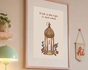 Puede incluir: Un cuadro enmarcado con una ilustración de una linterna decorativa con una vela encendida y detalles florales. El texto "Allah is the light in dark times" está encima. El marco es de color rosa claro.