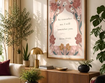 May include: A framed art print with a floral design and the text "So remember me; I will remember you. Quran (2:152)". The print is in a wooden frame and hangs on a wall above a wooden cabinet. The room has a modern, minimalist aesthetic.