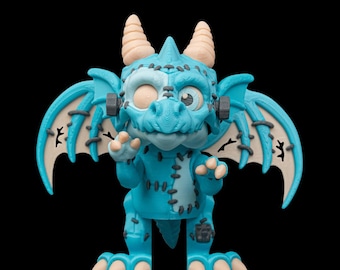 May include: A blue dragon figurine with tan horns, wings, and feet. The dragon has stitched seams, bolts on its head, and one eye open. The background is black.