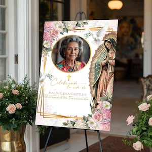 Peut inclure: Un panneau comm&eacute;moratif sur un chevalet noir pr&eacute;sente le portrait d'une femme &acirc;g&eacute;e, entour&eacute; de motifs floraux et religieux. Le panneau comprend le texte "Celebrando la vida de Mar&iacute;a Elena Castillo" et les dates de naissance et de d&eacute;c&egrave;s.