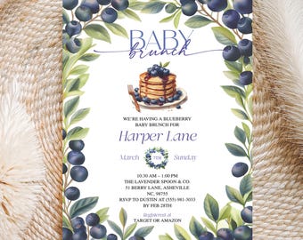 May include: Baby brunch invitation with a blueberry theme. The invitation features a stack of pancakes topped with blueberries, surrounded by a border of green leaves and blueberries. Text includes "Baby Brunch" and event details.