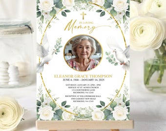 May include: A memorial card with a photo of a woman, surrounded by a gold frame, white roses, and doves. The text reads "In Loving Memory" and includes the name Eleanor Grace Thompson, dates, and service details.