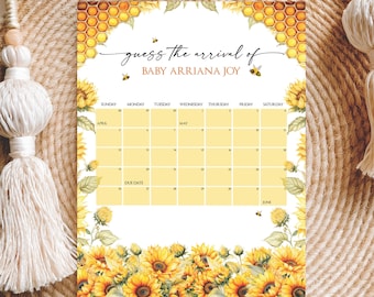 May include: A baby shower calendar with a sunflower and honeycomb design. The text reads "guess the arrival of BABY ARRIANA JOY." The calendar grid is yellow, with floral accents and bee illustrations. The calendar includes the months of April, May, and June.