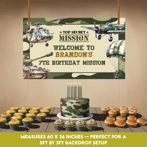 May include: A birthday party scene with a camouflage-patterned cake, cupcakes, and a banner that reads "Top Secret Mission" and "Welcome to Brandon's 7th Birthday Mission." The banner measures 60 x 36 inches.