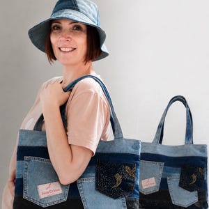 Może przedstawiać: Niebieski kapelusz typu bucket hat z dżinsu oraz dwie pasujące torby typu tote wykonane z dżinsowego patchworku. Torby posiadają poziome pasy z jasnego i ciemnego dżinsu, zewnętrzne kieszenie oraz prostokątną metkę z napisem Julia Orlova.