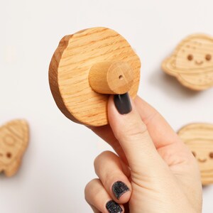 Puede incluir: Imanes de madera con tem&aacute;tica espacial. El conjunto incluye un planeta, un cohete, un astronauta y un im&aacute;n redondo con un mango de madera. Los imanes son de color marr&oacute;n claro y tienen detalles grabados. Sobre fondo blanco.