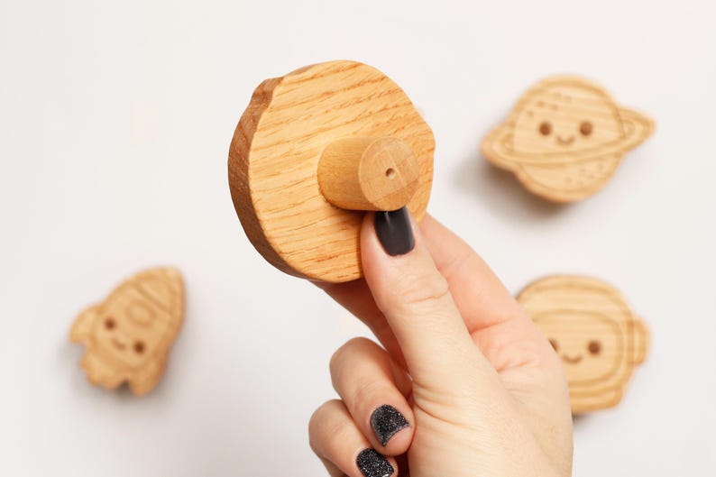 Puede incluir: Imanes de madera con tem&aacute;tica espacial. El conjunto incluye un planeta, un cohete, un astronauta y un im&aacute;n redondo con un mango de madera. Los imanes son de color marr&oacute;n claro y tienen detalles grabados. Sobre fondo blanco.