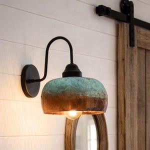 Puede incluir: Entrada rústica con consola de madera, cestas de mimbre y arreglo floral. Una lámpara de pared con acabado cobre y turquesa ilumina el espacio. Puertas de granero y un espejo redondo completan el estilo rústico.