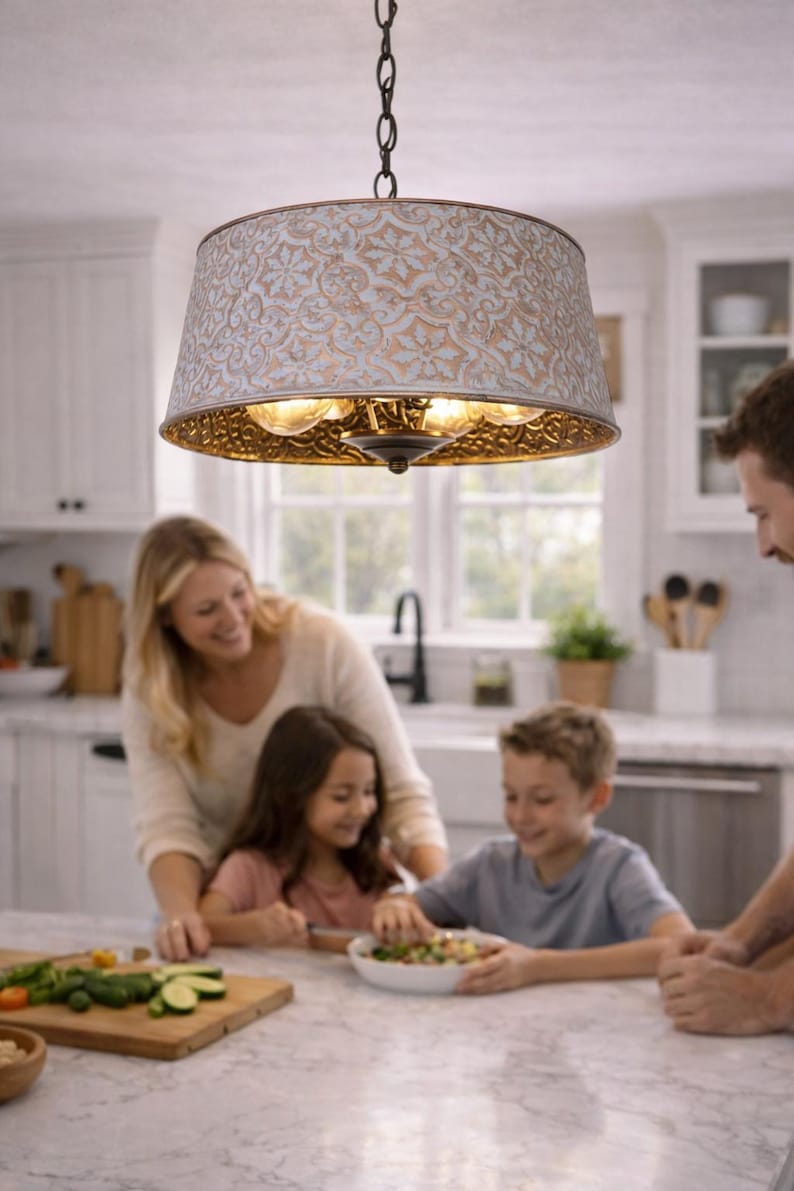 Puede incluir: Una l&aacute;mpara colgante decorativa con una pantalla estampada en blanco y dorado cuelga sobre una isla de cocina. La l&aacute;mpara tiene una cadena de metal y est&aacute; suspendida sobre una familia.