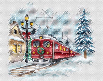 May include: Cross-stitch design of a red train with a Christmas wreath, traveling through a snowy winter scene. A house with lit windows and a lamppost with a red bow are on the left, and a blue evergreen tree is on the right.