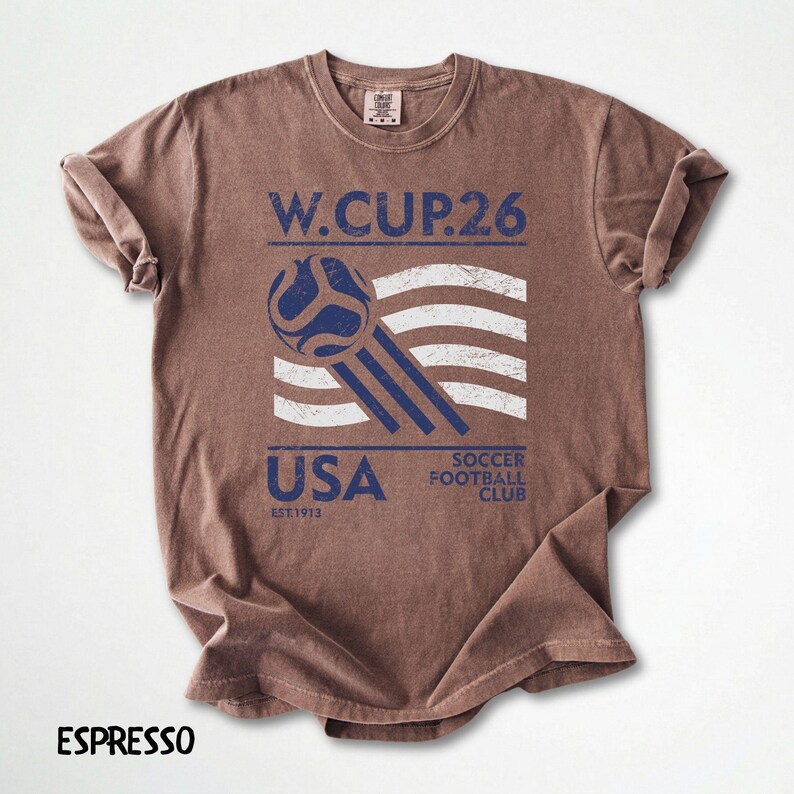 Close up of an espresso brown t-shirt with a white and blue vintage style USA Soccer Football Club print and soccer ball illustration.