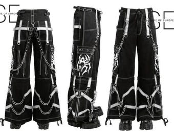 Puede incluir: Pantalones cargo negros con detalles blancos, cadenas y costuras decorativas. Los pantalones tienen múltiples bolsillos, correas y un diseño de pierna acampanada. La imagen muestra los pantalones desde múltiples ángulos.