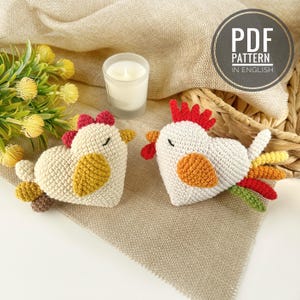Peut inclure: Deux poulets en crochet en forme de cœur, l'un rouge et l'autre jaune, avec les yeux fermés. Les poulets sont assis sur une surface en toile de jute beige.  PDF PATTERN IN ENGLISH.