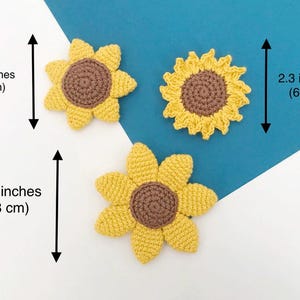 May include: Three handmade crochet sunflowers in yellow and brown. The largest sunflower measures 3.2 inches (8 cm) in diameter, while the smallest is 2.3 inches (6 cm). The sunflowers are displayed on a white and blue background.