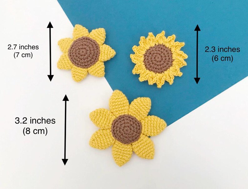 May include: Three handmade crochet sunflowers in yellow and brown. The largest sunflower measures 3.2 inches (8 cm) in diameter, while the smallest is 2.3 inches (6 cm). The sunflowers are displayed on a white and blue background.