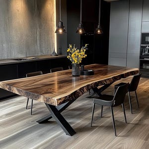 Puede incluir: Una gran mesa de comedor de madera con bordes naturales, que muestra una veta oscura y rica. La mesa está sostenida por una base de metal negro. Sillas negras la rodean, y un jarrón con flores amarillas está en el centro.