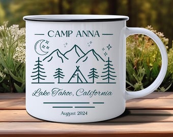 May include: White enamel camping mug with a black rim and handle. The mug has a green line design of mountains, a crescent moon, stars, pine trees, and a tent. The text on the mug reads "Camp Anna - Lake Tahoe, California - August 2024".