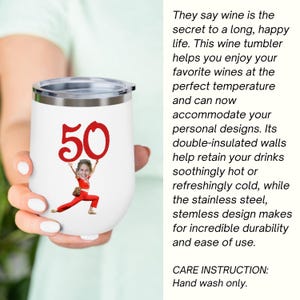 May include: White stemless wine tumbler with a silver rim, featuring a red "50" graphic and a person's image. The tumbler has text that says, "They say wine is the secret to a long, happy life."