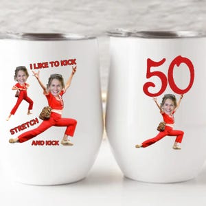 May include: Two white stemless wine tumblers with a red graphic. One tumbler has the text "I LIKE TO KICK STRETCH AND KICK" and a cartoon image. The other has the number "50" and a cartoon image.