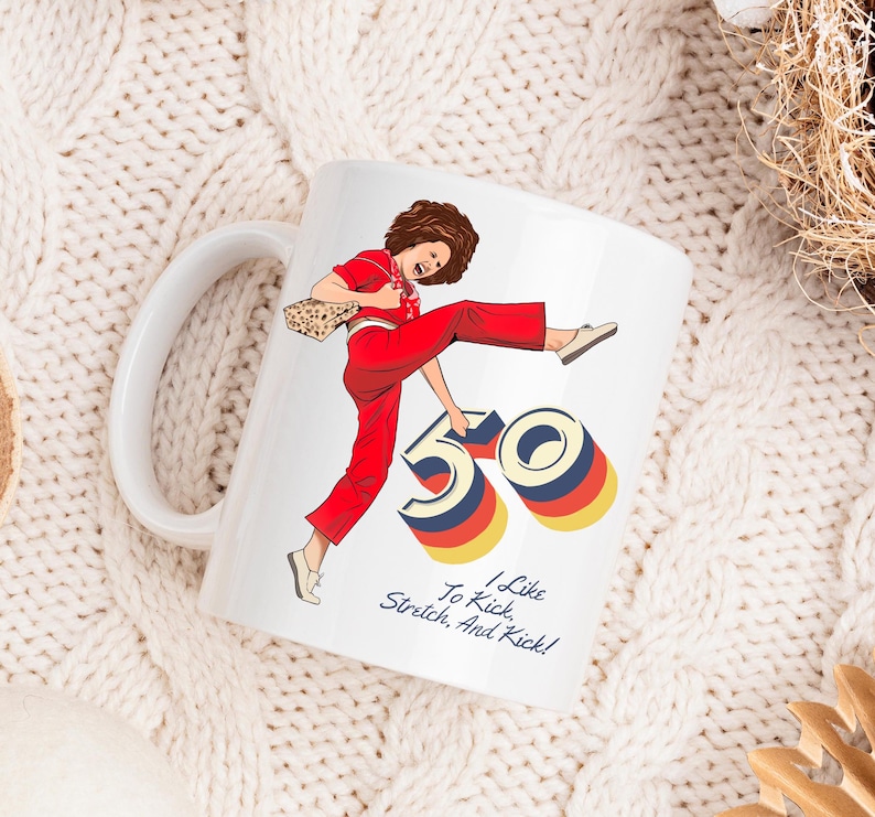 May include: White ceramic mug with a colorful illustration of a woman kicking a large number 50. The text "I Like To Kick, Stretch, And Kick!" is printed below the illustration.