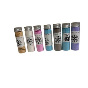 May include: Seven small glass vials with silver lids, each containing a different colored powder. The colors include beige, white, pink, blue, gray, teal, and purple. Each vial has a white label with black text and a snowflake design.