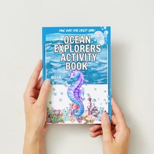 May include: A blue and white activity book with the title "Ocean Explorers Activity Book" and a colorful illustration of a seahorse in a coral reef. The book is for ages 4-8.