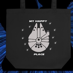 Puede incluir: Bolsa de tela negra con texto blanco y un gráfico de una nave espacial. El texto dice "My Happy Place".