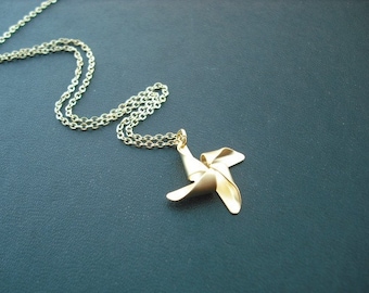 May include: A gold chain necklace with a gold pinwheel pendant.