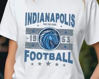 May include: White t-shirt with a blue and gray graphic design featuring a horse head and the text "Indianapolis for the shoe 19 53 Football".