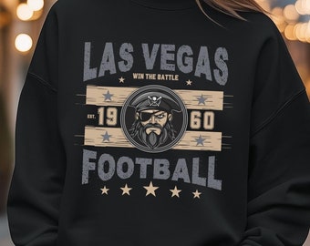 Può includere: Felpa nera con una stampa grafica bianca che dice "Las Vegas Win the Battle 19 60 Football" con un logo di teschio di pirata e ossa incrociate.