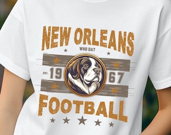 May include: White t-shirt with a brown and gold graphic design featuring a dog head and the text "NEW ORLEANS WHO DAT EST. 1967 FOOTBALL".