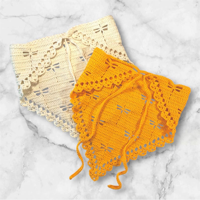 K&ouml;nnte beinhalten: Zwei geh&auml;kelte Bandanas. Eines ist cremefarben, das andere leuchtend gelb. Beide haben ein Libellenmuster und einen gewellten Rand. Jedes Bandana hat einen Kordelzug zum Binden.