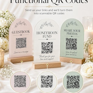 May include: Three arched acrylic signs in pastel pink, white, and sage green, each with a QR code and text including GUESTBOOK, HONEYMOON FUND, and SHARE YOUR PHOTOS. Below are three circular tags with matching QR codes and labels on wooden stands.