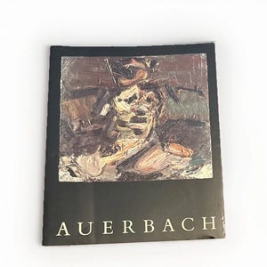 May include: A black art print with the name "AUERBACH" in white text at the bottom. The artwork features an abstract painting with a mix of brown, beige, and white colors. The print is on a white background.