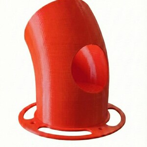 K&ouml;nnte beinhalten: Ein leuchtend rotes, 3D-gedrucktes Rohrbogenst&uuml;ck mit einer kreisf&ouml;rmigen &Ouml;ffnung. Das Rohr hat ein gebogenes Design und einen kreisf&ouml;rmigen Sockel mit drei L&ouml;chern. Das Objekt besteht aus einem festen, strukturierten Material.