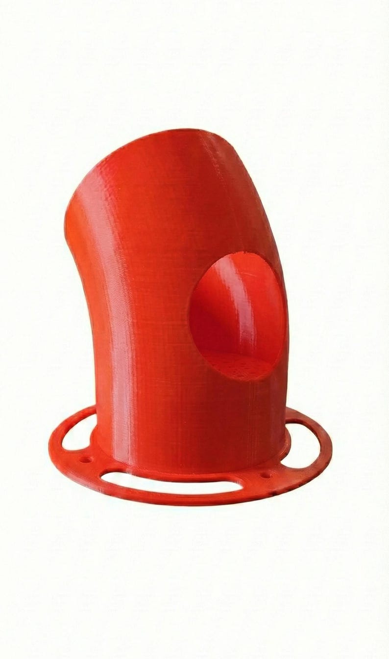 K&ouml;nnte beinhalten: Ein leuchtend rotes, 3D-gedrucktes Rohrbogenst&uuml;ck mit einer kreisf&ouml;rmigen &Ouml;ffnung. Das Rohr hat ein gebogenes Design und einen kreisf&ouml;rmigen Sockel mit drei L&ouml;chern. Das Objekt besteht aus einem festen, strukturierten Material.