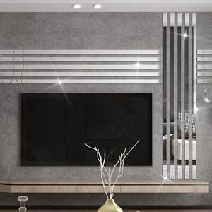 Puede incluir: Una sala de estar moderna con un televisor de pantalla plana montado en una pared con un diseño decorativo de azulejos de espejo. Los azulejos de espejo están dispuestos en un patrón horizontal sobre el televisor y en un patrón vertical a la derecha del televisor. La pared está pintada de gris claro.